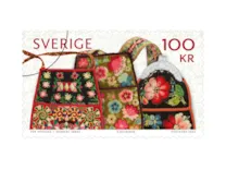 Rullfrimärke med motiv av broderade kjolväskor.