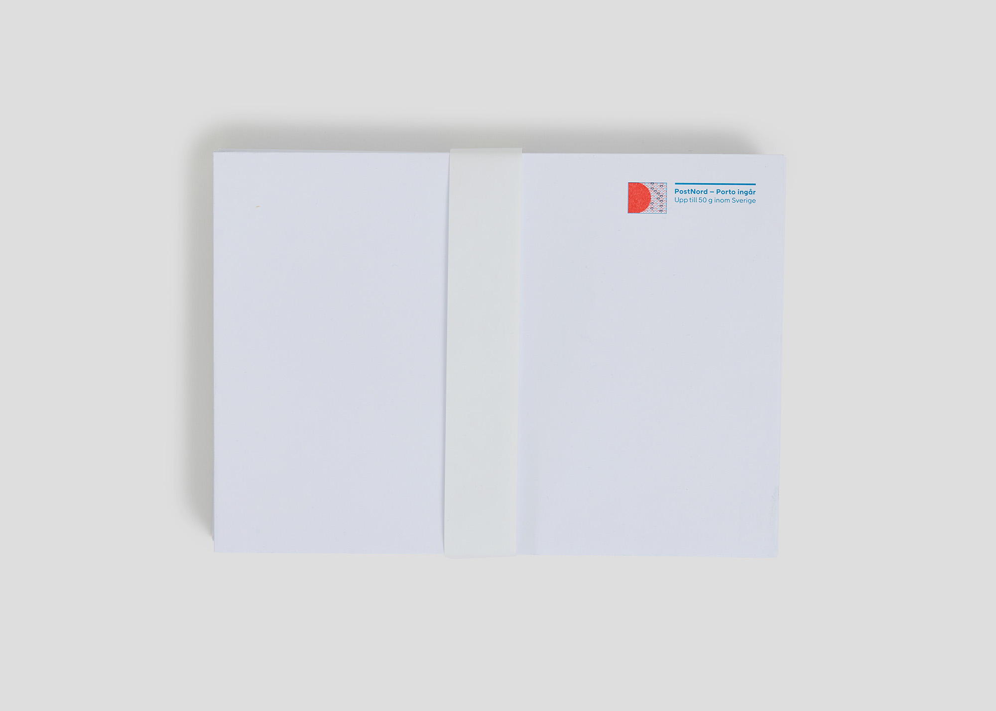 En bunt med 50 stycken kuvert med en banderoll runt.