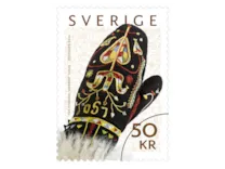 Rullfrimärke med motiv av en vackert broderad svart brudvante med färgglada mönster.