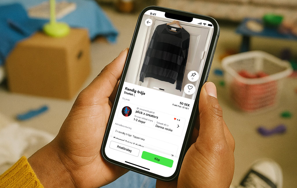 En hand håller upp en mobiltelefon. På skärmen syns köp -och sälj-appen plick.